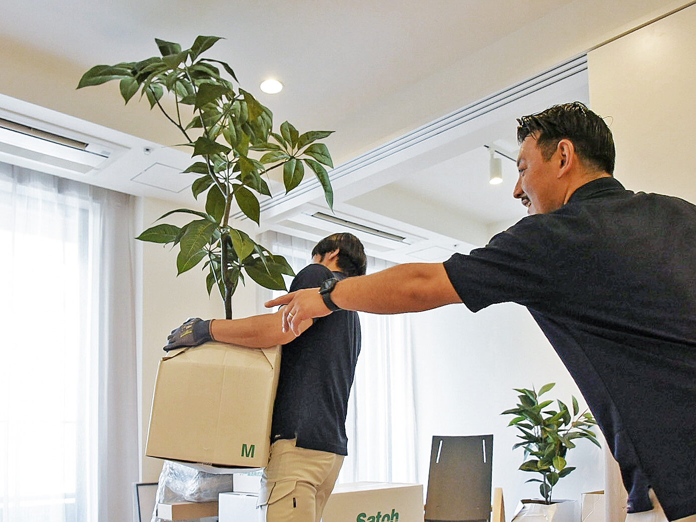 植栽を置く場所を指示するサトー運送の作業員。